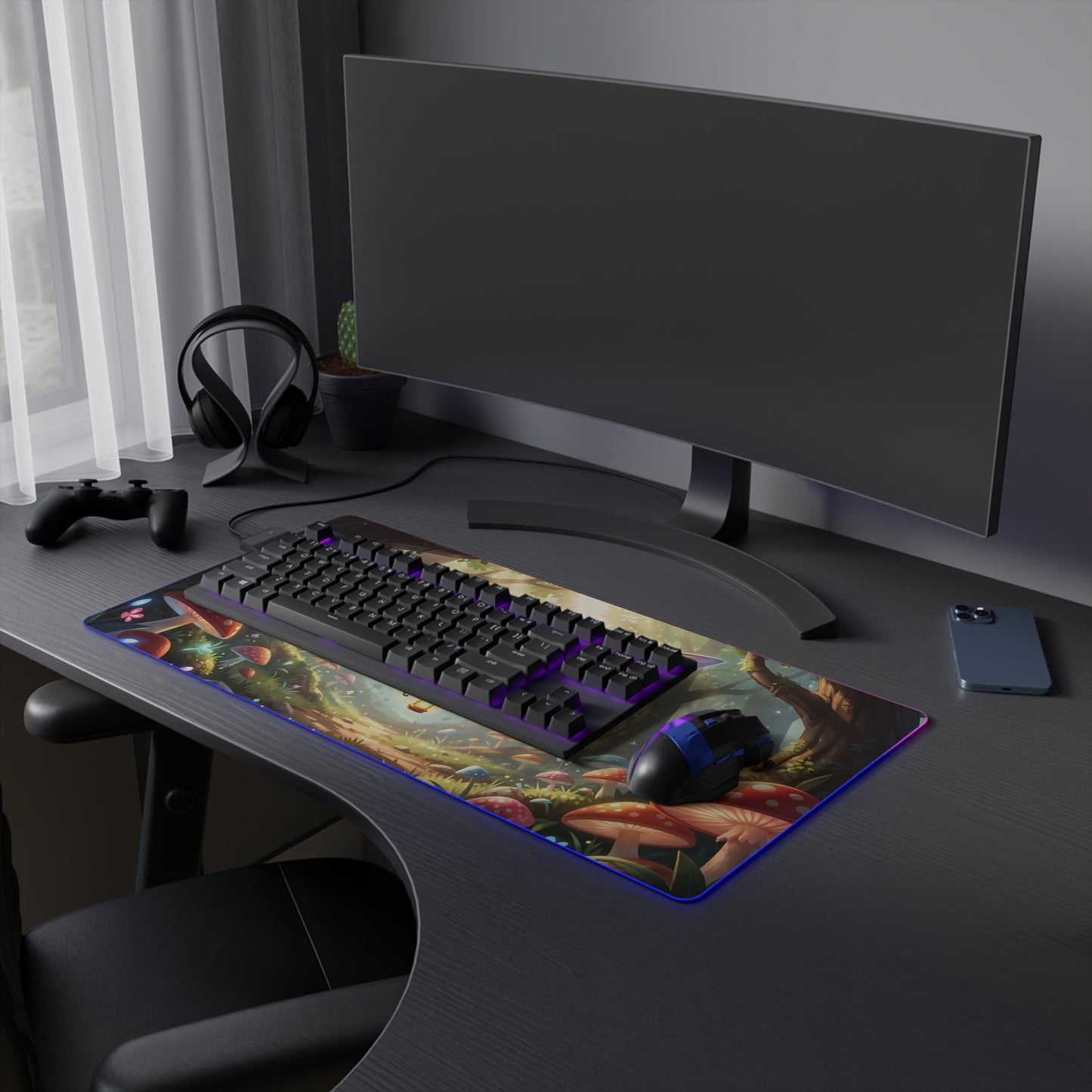 LED gaming mouse pad with fairy bee forest artwork and blue RGB border beside keyboard.