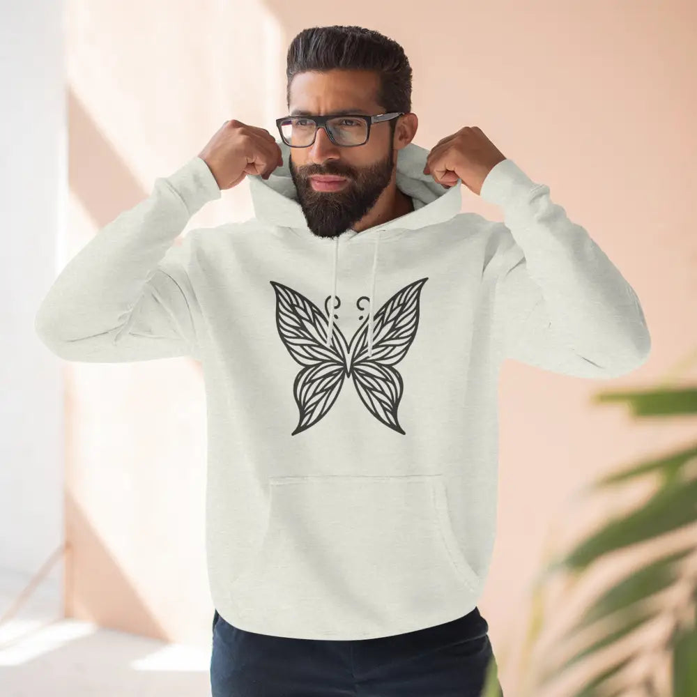 Man wearing a cream-colored fleece hoodie with black butterfly design, casual fall wear