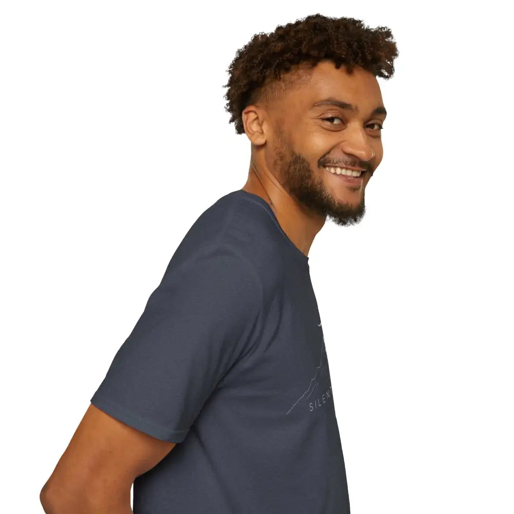 Smiling man with curly hair in a dark blue softstyle t-shirt with ribbed knit collar