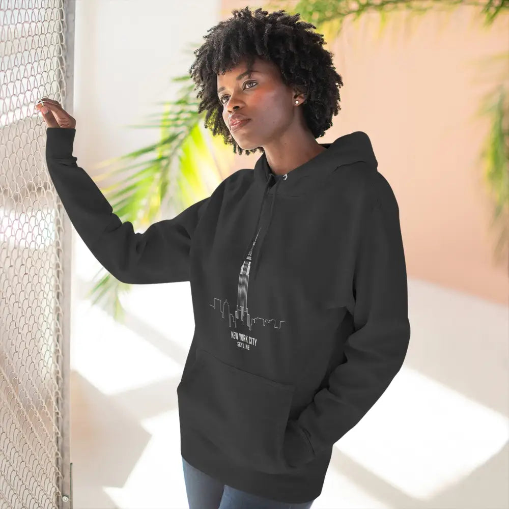 Woman in black hoodie with NYC skyline outline, machine wash cold low heat, stylish urban fashion