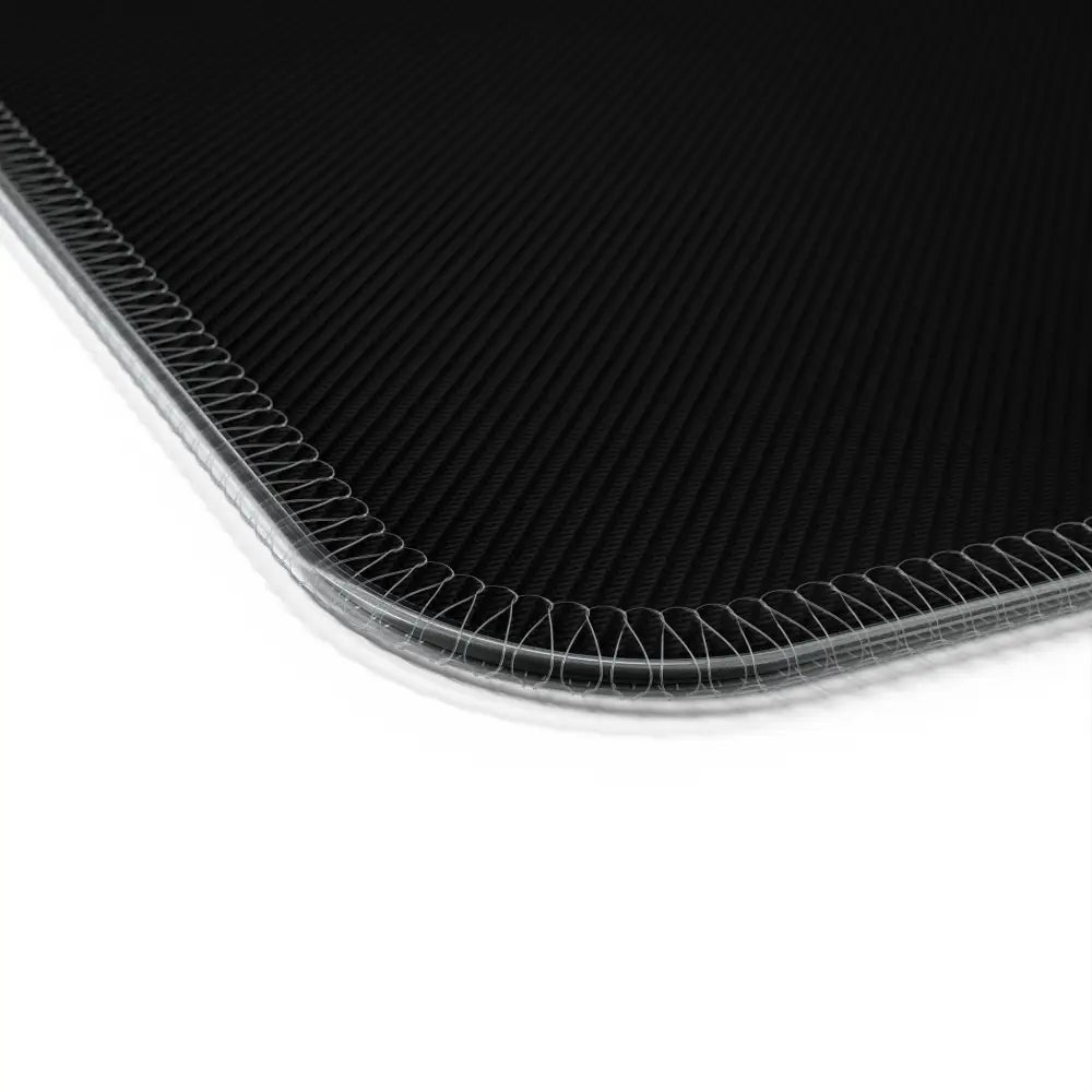 Black carbon fiber mouse pad with stitched edges featuring wireless charging for gaming setups